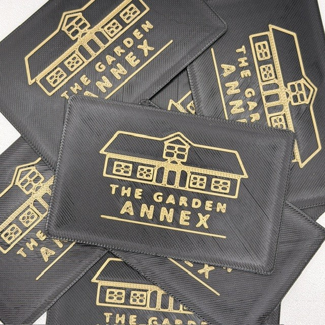 Black and gold 3D-printed NFC cards branded with The Garden Annex logo