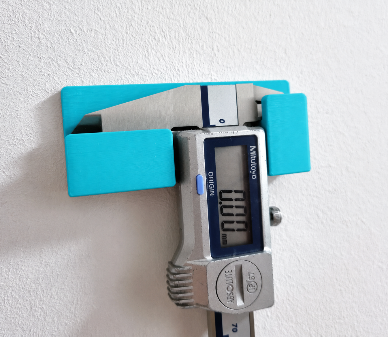 Mitutoyo digital vernier caliper stored in turquoise wall holder